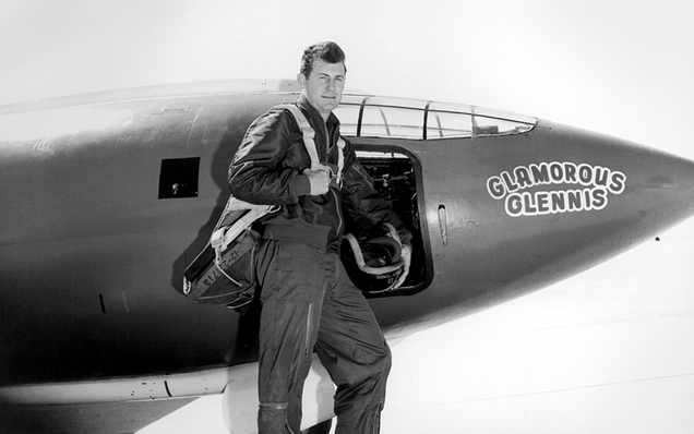 Yeager poses next to the X-1. The first X-1 was painted international orange to make it more visible. Later versions received white accents, and later aircraft were either bare aluminum or white. (NASA)